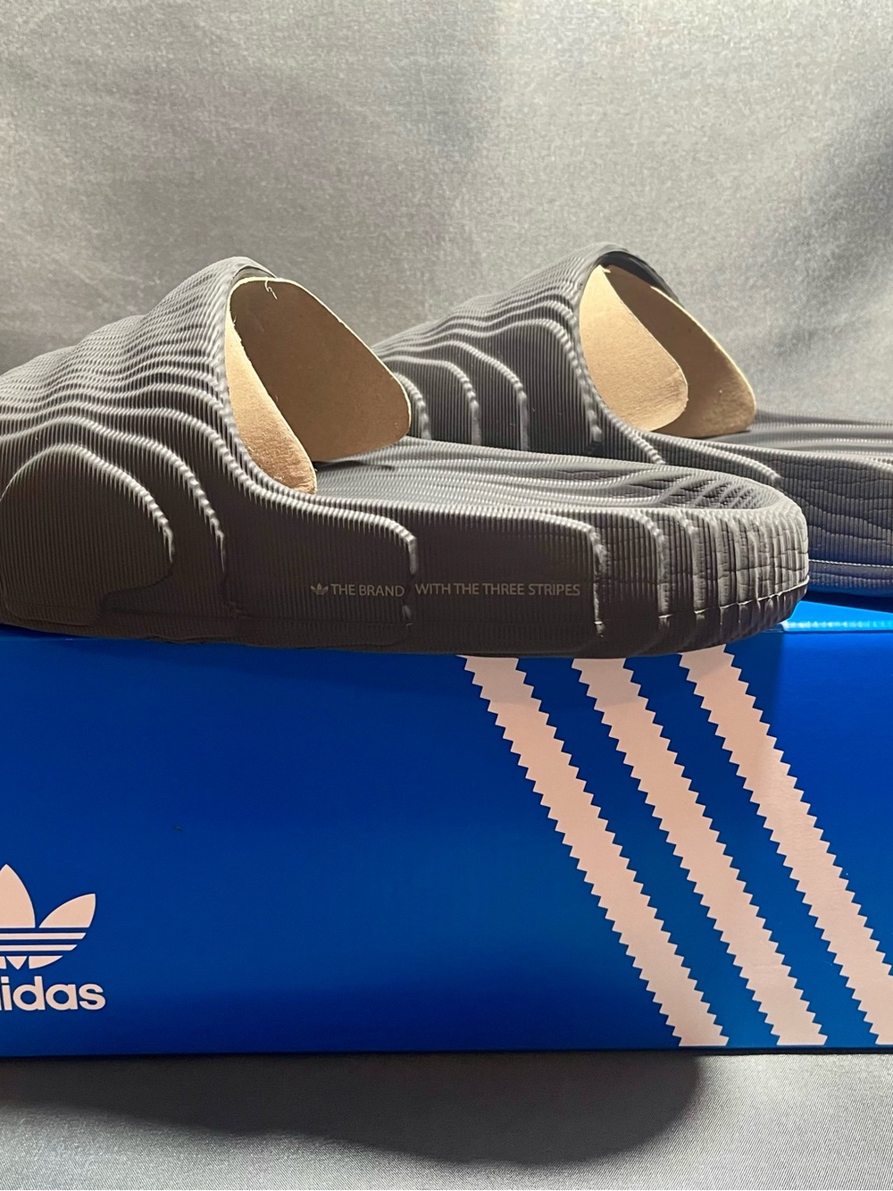 adidas Mens Adilette 22 slides—a futuristic-looking slip-on sandal.